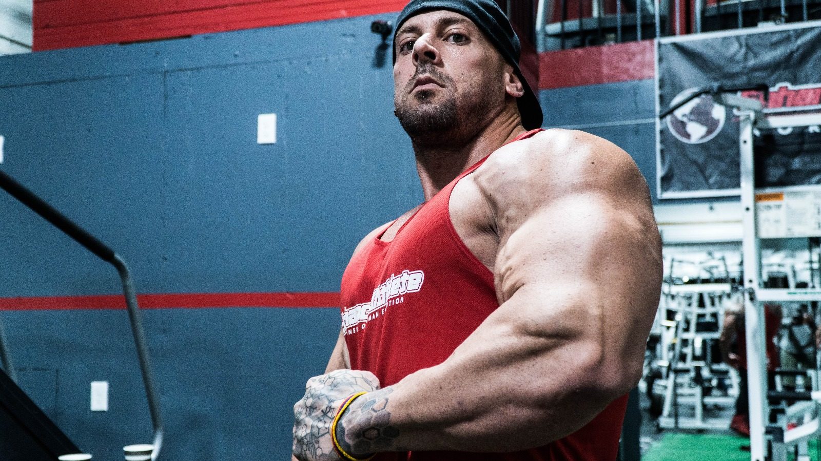 Coach Trevor in a red Enhanced Athlete tank in the gym